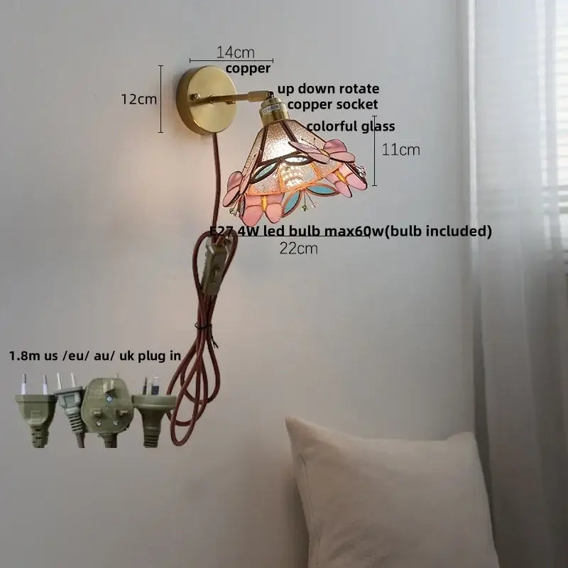 A decorative floral pink and teal decorbites butterfly glass wall light with copper-finished arm for bedroom decor