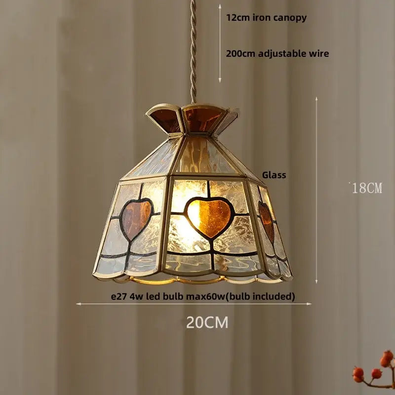 A warm-toned floral red and amber crown diamond glass pendant lamp with heart-shaped panels in a brass frame