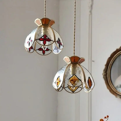 Two handcrafted floral red and amber glass pendant lamps with amber-toned metal frames by decorbites crown diamond