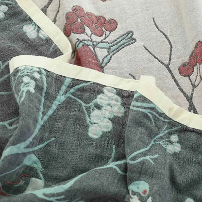 Gray cotton gauze summer blanket featuring a delicate red and white berry botanical print with cream stitched border