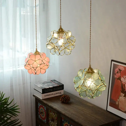 Three floral stained glass pendant lights with gold-toned copper led frames in pink clear and green for dining room use