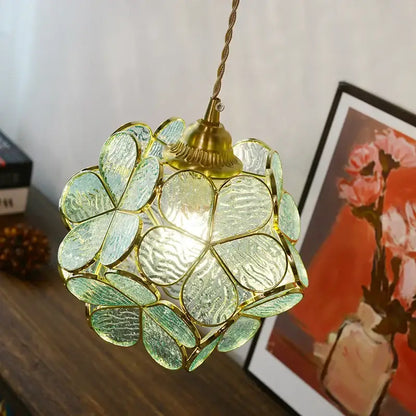 A gold-toned floral stained glass pendant light fixture with green textured petals and glass copper led design for dining room