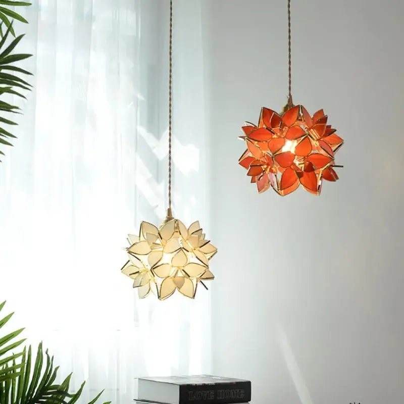 Two hanging floral stained glass pendant lights with orange and cream petals and copper led light fixture design