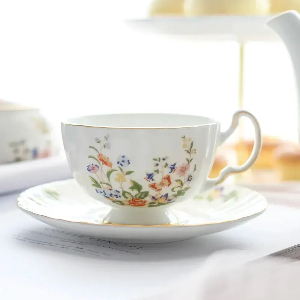 A delicate white bone china tea cup with gold rim and vibrant floral pattern in a floral tea cup set