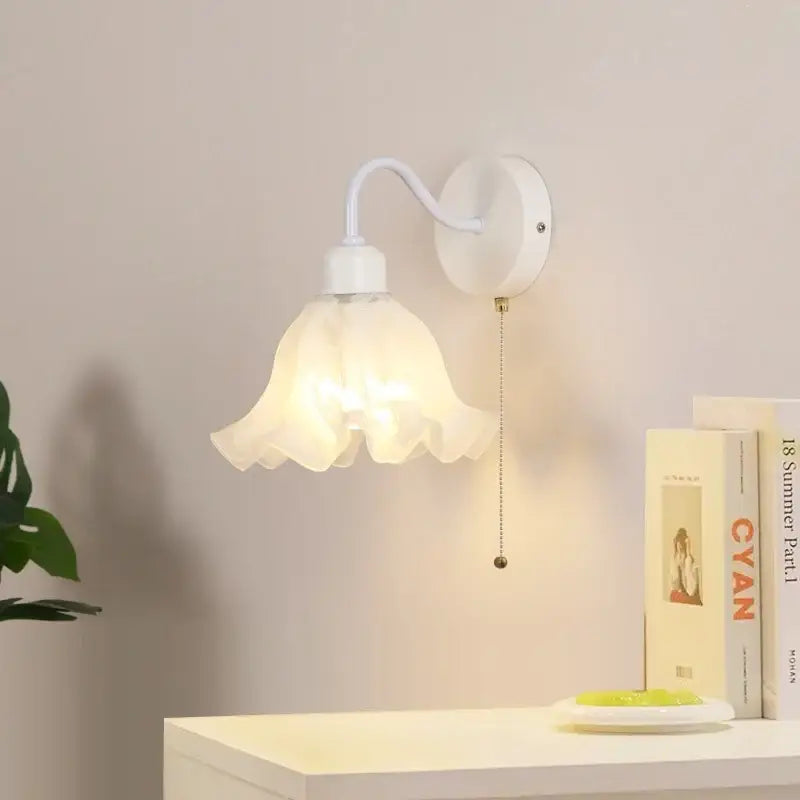 White wall sconce with translucent petal-shaped glass shade and curved metal arm decorbites glass iron led design