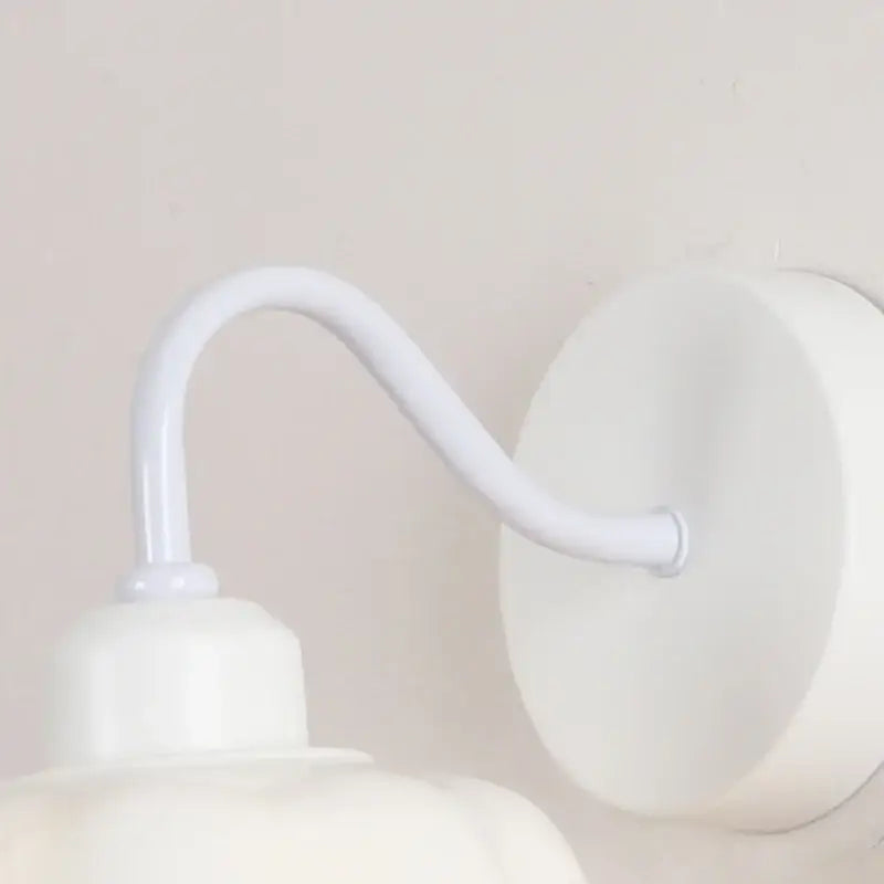 Floral white glass iron led wall sconce with pull chain featuring a white metal curved arm and circular backplate decorbites glass iron