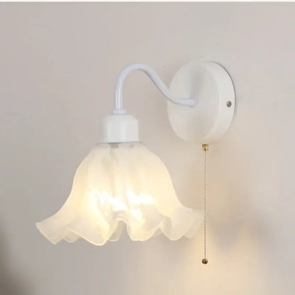 Floral white glass wall sconce with frosted flower-shaped shade and curved arm with pull chain switch stair light