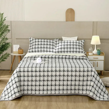 Black and white houndstooth patterned quilt with textured weave draped over bed in decorbites cotton double bedspread set