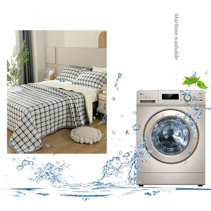 Silver front-loading washing machine with digital display next to floral white and green decorbites cotton double bedspread set