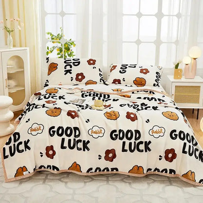 Cream-colored cozy flannel plush blanket with brown rabbit pattern floral motifs and good luck text for decorbites bedroom throw