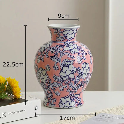 A pink porcelain vase with white porcelain interior and intricate blue floral patterns for living room decor