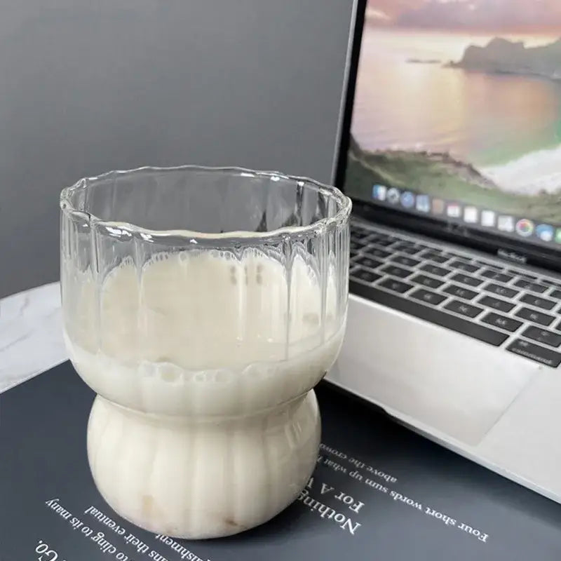 Clear fluted glass coffee mug with a bulbous base filled with creamy liquid from decorbites glass collection