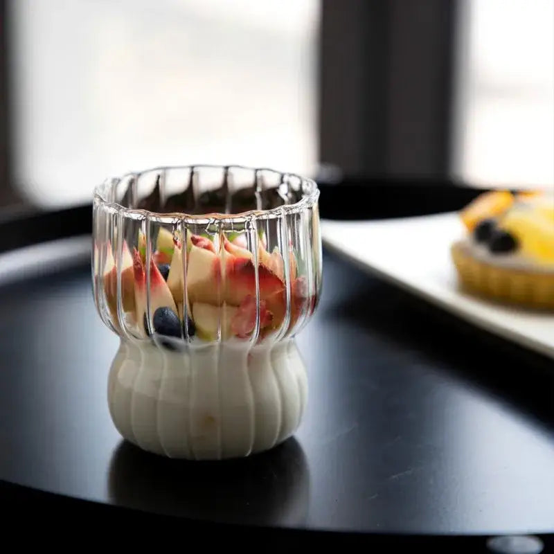 Clear ribbed glass coffee mug with white fluted base holding layered fruit and yogurt from decorbites glass coffee collection