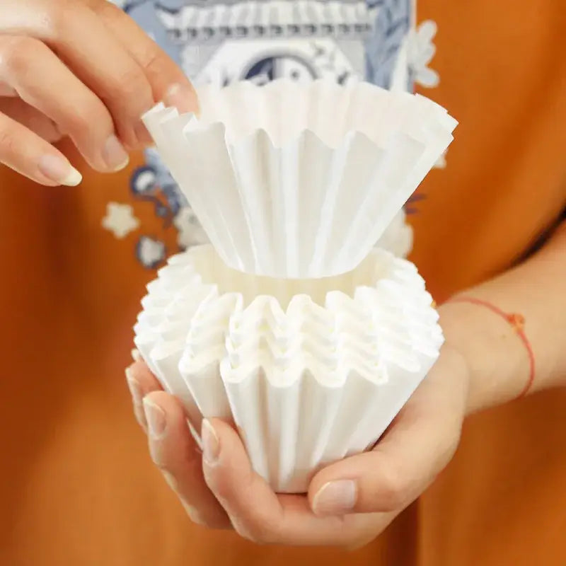 Hands holding fluted white disposable paper coffee filters decorbites coffee filters for kitchen use