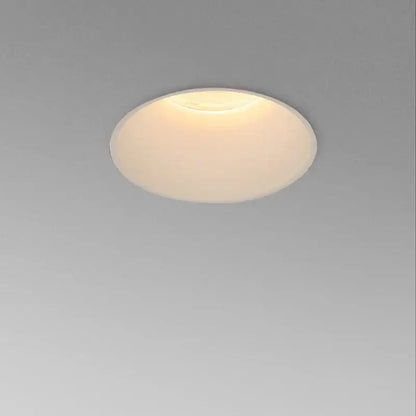 A frameless white decorbites cob led downlight with frosted glass diffuser emitting warm ambient living room light