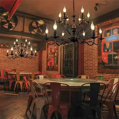 Black wrought iron french candle chandelier with multiple lit candle-style bulbs in antique bronze for dining room lighting