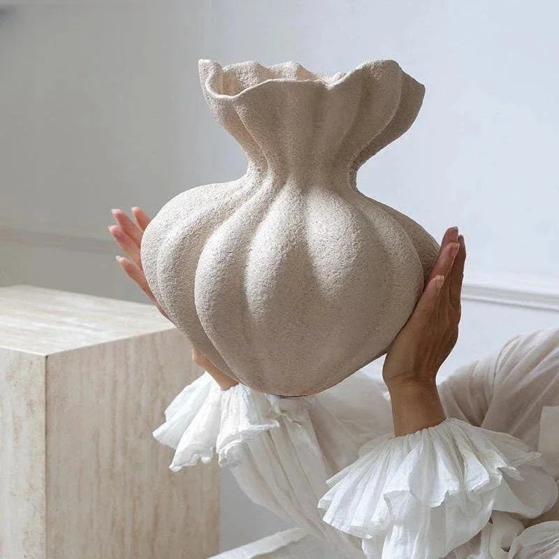 A textured off-white ceramic vase with a fluted ruffled rim and bulbous body for minimalist floral decor