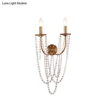 Antique brass two-light wall lamp with brushed brass finish and clear crystal bead strands for bedroom sconce lighting