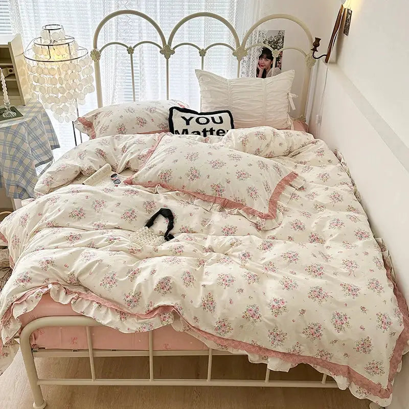 Floral-patterned bedding set with double layer lace ruffles in cream and purple featuring delicate pink hues and soft pastel tones