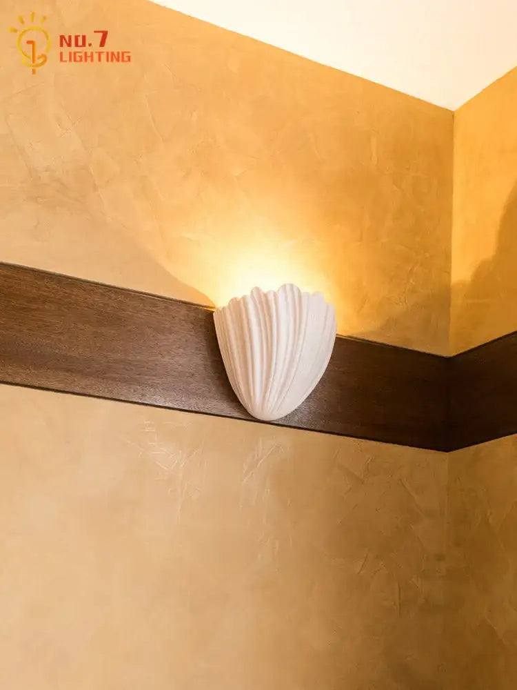 White shell-shaped wall lamp with smooth glossy finish in french medieval style for bedroom decorbites french medieval