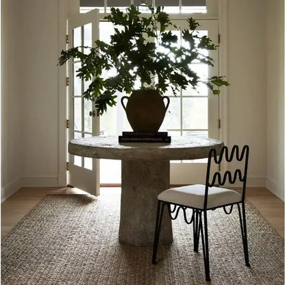 A rustic terracotta vase with two handles holding a green leafy plant complementing decorbites french retro wave dining table set