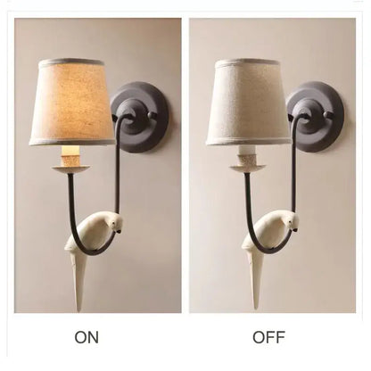 White ceramic parrot-shaped wall lamp with dark metal frame and fabric shade in bird decor antique style for bedroom decorbites
