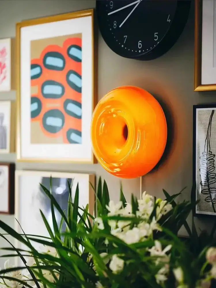 Vibrant orange translucent glass decorative wall lamp with donut-shaped design for bedroom lighting
