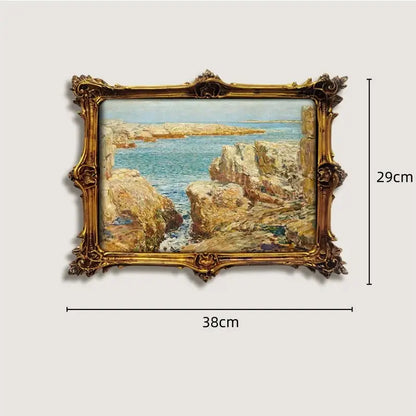 An ornate gold and wood framed french vintage cupid painting featuring a coastal scene with rocky cliffs and turquoise water