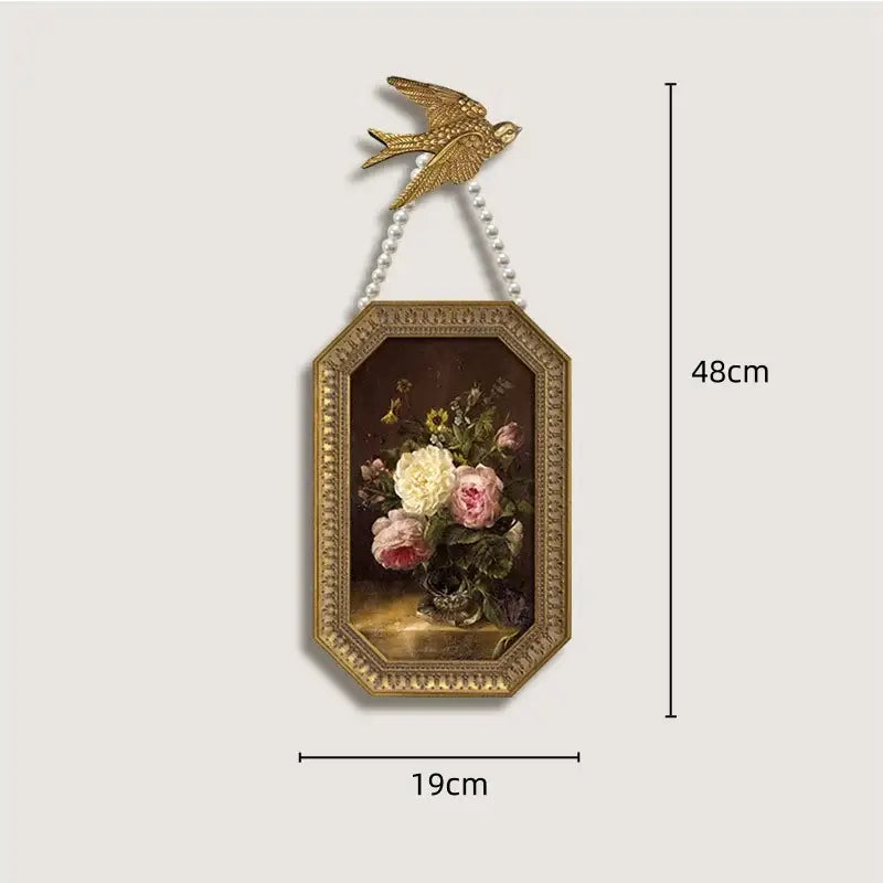 Gold-toned ornate octagonal French vintage cupid frame with painted floral still life and pearl chain wall decor