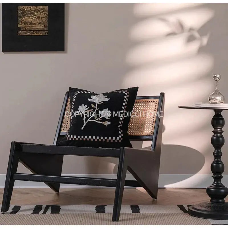 Black cushion with white floral embroidery and checkered border on black cane chair decorbites french vintage style