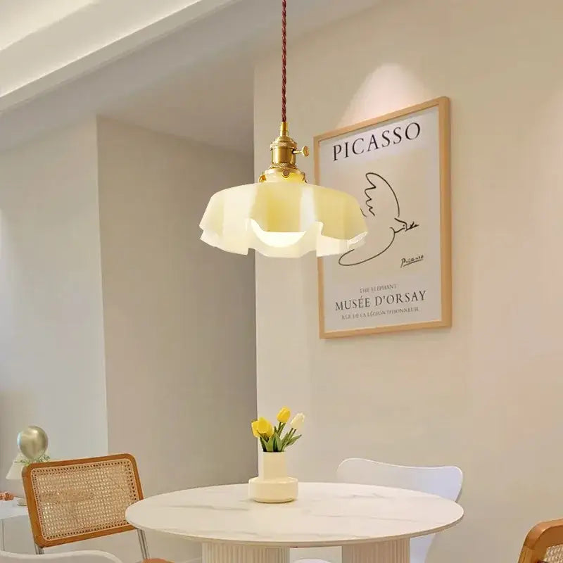 A cream-colored glass pendant light with brass fixture and braided cord by decorbites french vintage for kitchen island
