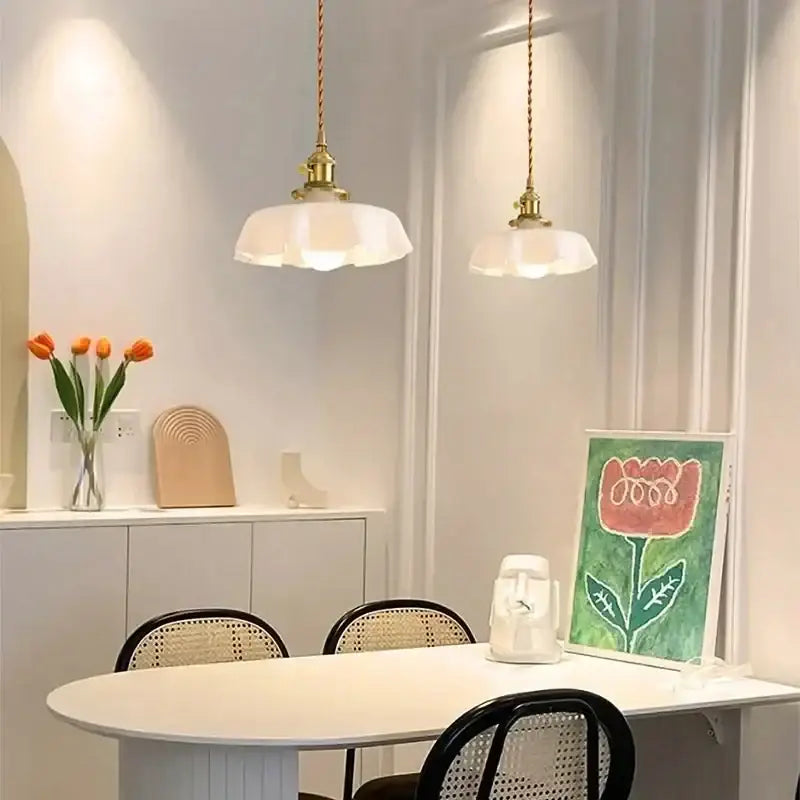 Two elegant white pendant lights with brass fixtures hang above a dining table decorbites french vintage pendant light