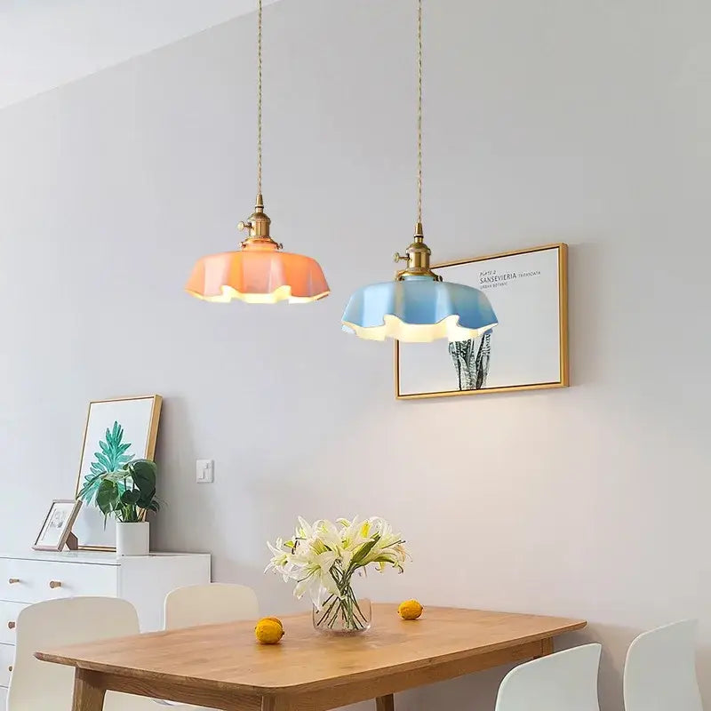 Two brass fixture pendant lights with pastel mint green glass shades hang above wooden dining table decorbites french vintage pendant