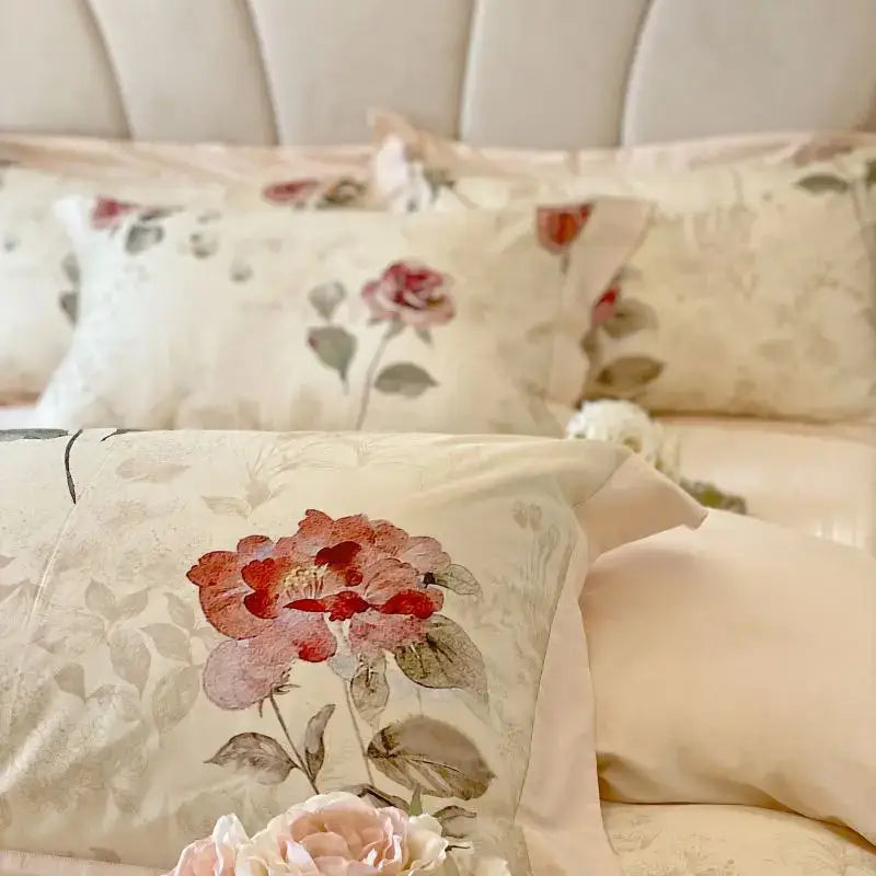 Cream-colored pillow with embroidered red and pink roses on subtle floral background from decorbites french vintage rose bedding set