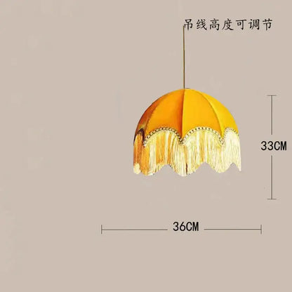 A vibrant yellow beauvamp tassel pendant light with cream fringed trim and adjustable cord for living room use