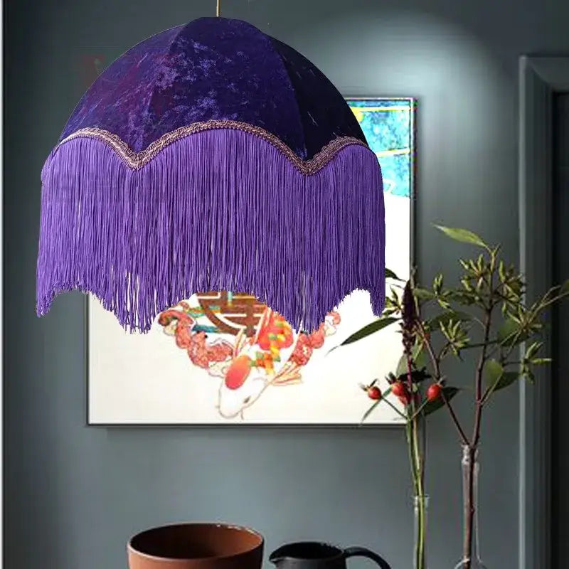 A deep purple velvet beauvamp tassel pendant light with cascading fringe and gold-trimmed edge for living room