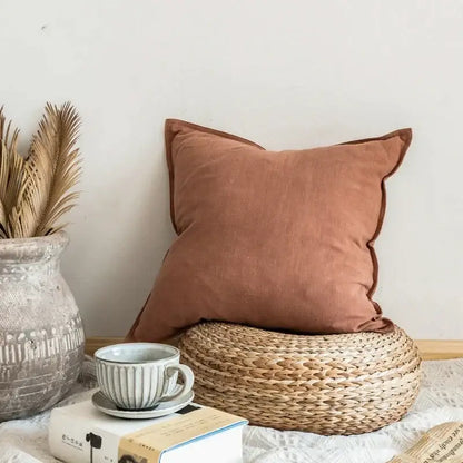 A soft rust-colored decorbites linen pillow cover with textured surface and neatly stitched edges for living room decor