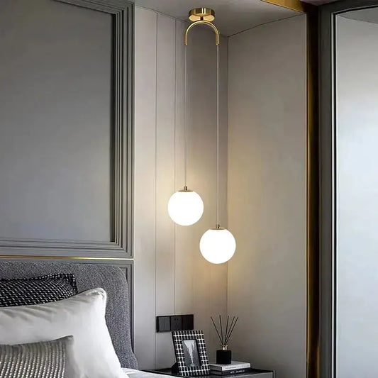 Two frosted glass pendant lights with gold-toned metal fixtures hang from the ceiling for dining room use