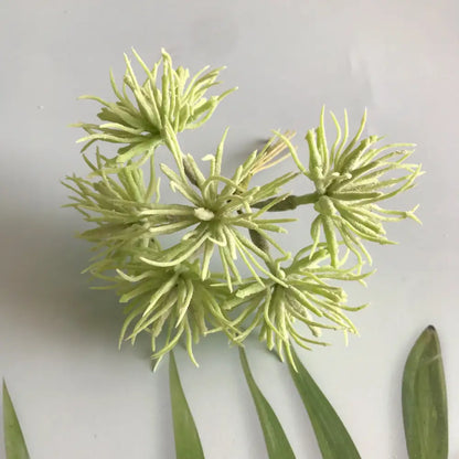 A cluster of artificial light green spiky flowers with feathery petals in a frost greenery berry stamen bundle decor