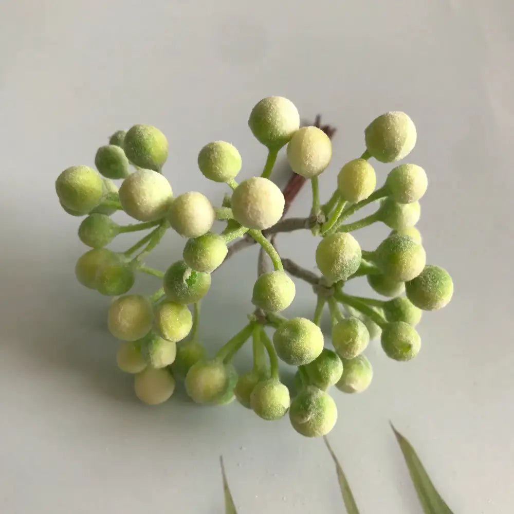 A frosted greenery berry stamen bundle with artificial green berries on thin stems for living room decorbites decor