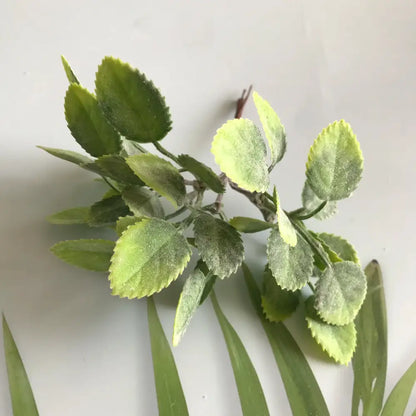 Artificial green leafy branch with variegated foliage and textured surface in frosted greenery berry stamen bundle decorbites greenery berry