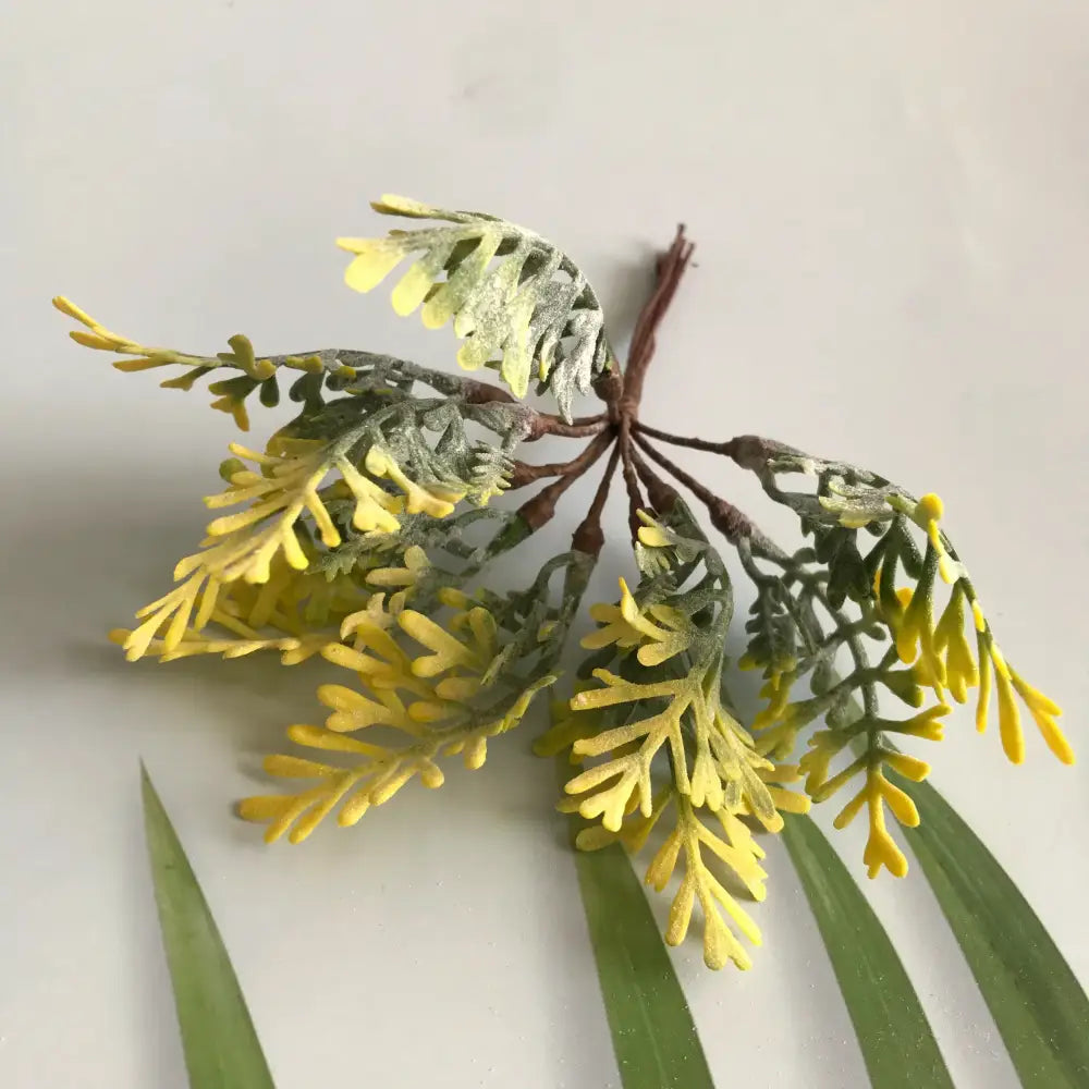 Artificial fern sprig with yellow and green feathery leaves on brown stem in frosted greenery berry stamen bundle decorbites greenery berry