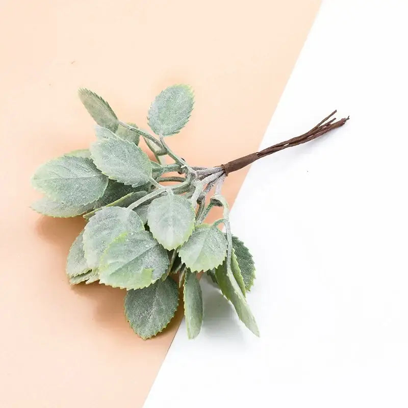 A delicate frosted light green artificial plants sprig with a dark brown stem from decorbites decorative artificial bundle