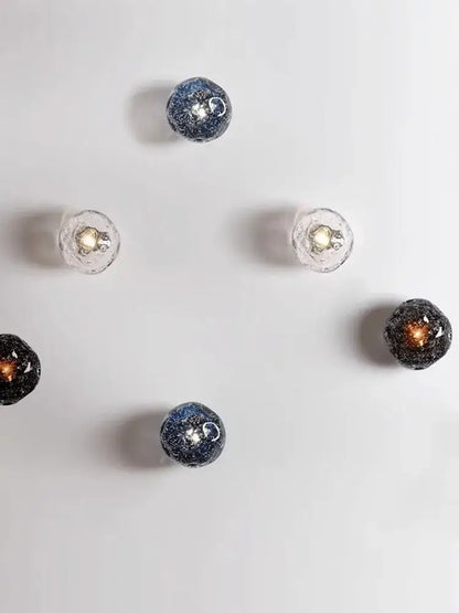 Galaxy blue and amber glass wall sconce lamps feature spherical glass with embedded glitter for living room lighting