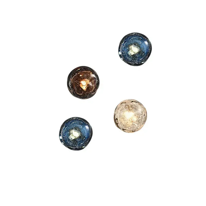 Four round glass orbs with swirling galaxy-like blue and amber patterns in galaxy blue and amber glass wall sconce lamps