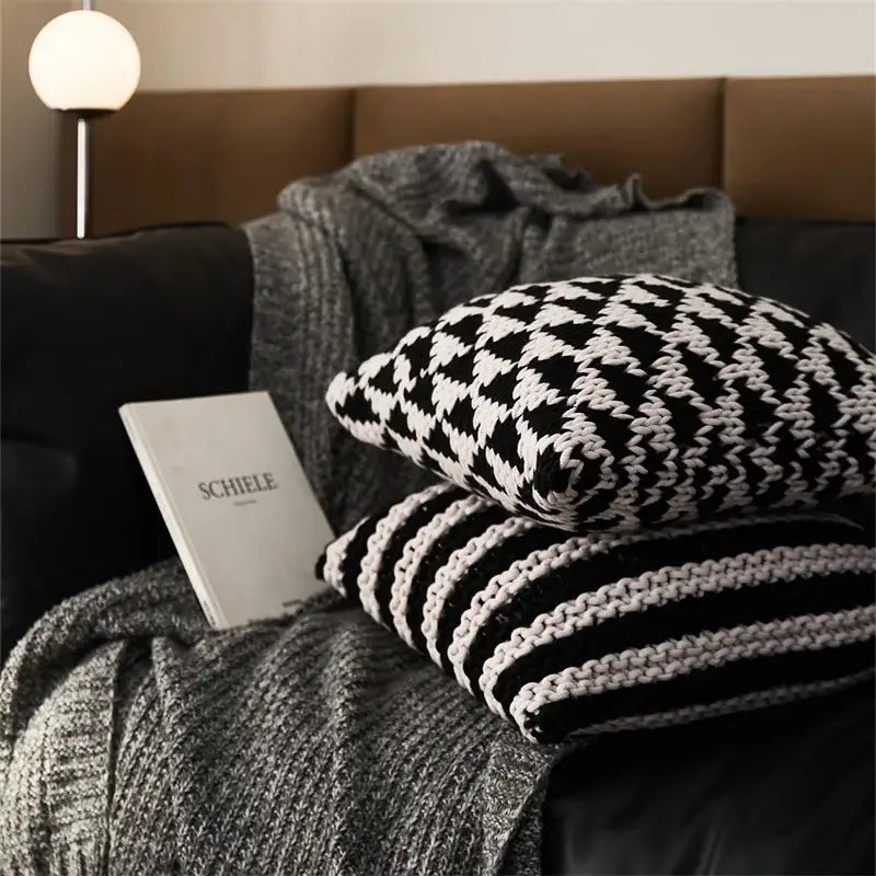 Black and white geo knit stripe square pillow with houndstooth and striped design on gray knit blanket decorbites geo knit