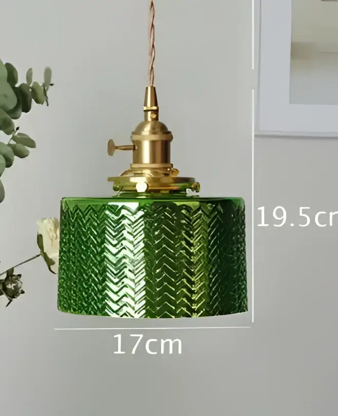 Green glass pendant light with textured chevron pattern and brass hardware for dining room use