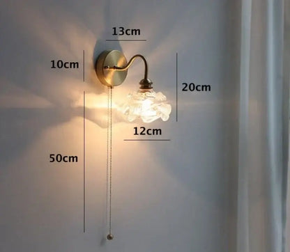 Vintage-style brass wall sconce with frosted glass flower shade complements dining room glass pendant light decor