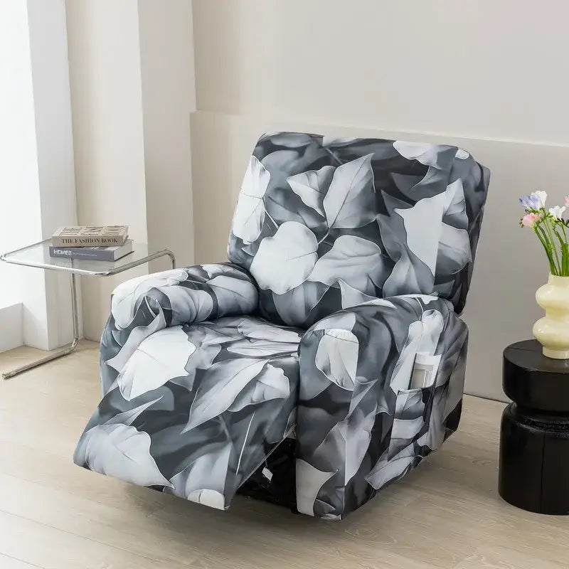 A sleek black and white leaf-patterned stretch recliner cover snugly fitting a living room chair