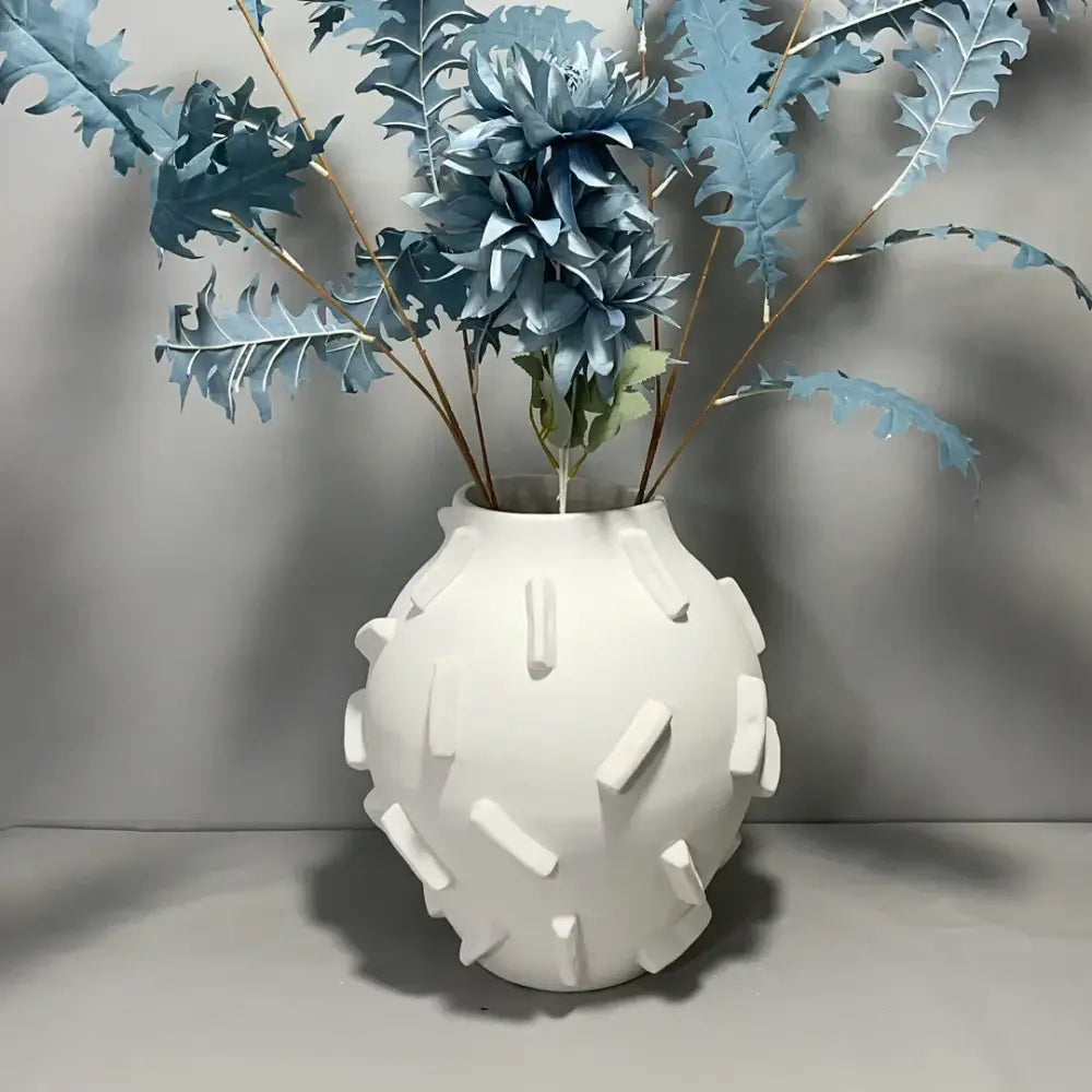 White ceramic geometric block ceramic vase with rounded body and rectangular ridges for green and beige decorbites decor